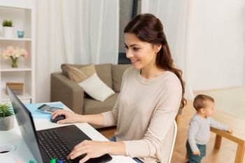 motherhood, multi-tasking, family and technology concept - happy mother with baby and laptop working at home. happy mother with baby and laptop working at home