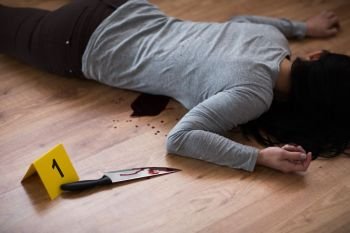 murder, kill and people concept - dead woman body and knife in blood lying on floor at crime scene (staged photo). dead woman body lying on floor at crime scene