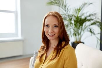 business and people concept - portrait of smiling redhead woman at office. portrait of smiling redhead woman at office