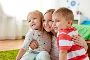 childhood, leisure and family concept - happy little kids hugging at home. happy little kids hugging at home