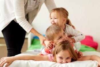 childhood, leisure and family concept - mother and happy little kids having fun at home. mother and happy little kids having fun at home