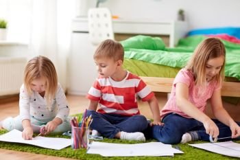 childhood, leisure and people concept - happy kids drawing and making crafts at home. happy kids drawing at home