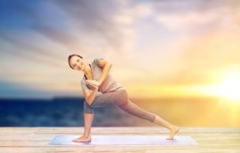 fitness, sport, people and healthy lifestyle concept - woman making yoga low angle lunge pose on pier over sea background. woman making yoga low angle lunge pose on mat