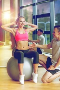 sport, fitness, lifestyle and people concept - smiling man and woman with exercise ball in gym. smiling man and woman with exercise ball in gym