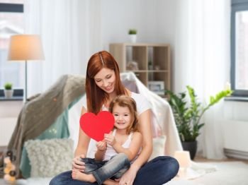 childhood, parenting and relationship concept - happy mother with adorable little girl and red heart over kids room and tepee background. happy mother with adorable little girl and heart