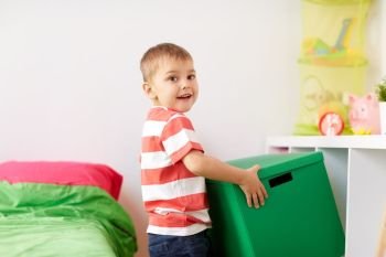 childhood, leisure and people concept - happy little boy with toy box at home. happy little boy with toy box at home