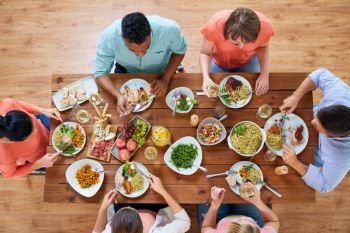 eating and leisure concept - group of people having dinner at table with food. group of people eating at table with food