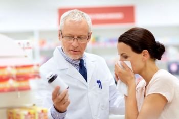 medicine, healthcare and people concept - senior apothecary with drug and female customer having cold and blowing nose at pharmacy. apothecary and sick customer at pharmacy