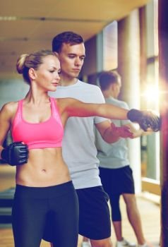sport, fitness, lifestyle and people concept - smiling woman with personal trainer boxing in gym. smiling woman with personal trainer boxing in gym