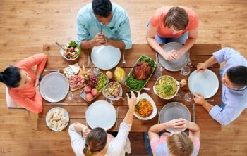 thanksgiving day, eating and leisure concept - group of people having dinner at table with food. group of people eating at table with food