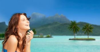 travel, tourism, summer holidays and vacation concept - happy young woman enjoying sun at touristic resort over bora bora island beach background. happy woman enjoying sun on bora bora beach