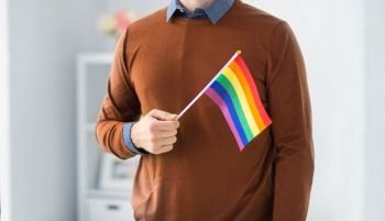 gay pride, lgbt and homosexual concept - close up of man with rainbow flag. close up of man with gay pride flag. close up of man with gay pride flag