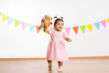 childhood, people and celebration concept - happy baby girl with teddy bear toy on birthday party. happy baby girl with teddy bear on birthday party. happy baby girl with teddy bear on birthday party