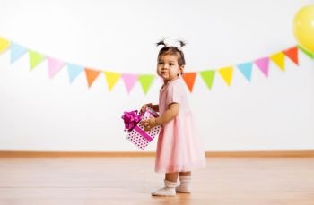 childhood, people and celebration concept - happy baby girl with gift box on birthday party. happy baby girl with gift box on birthday party. happy baby girl with gift box on birthday party