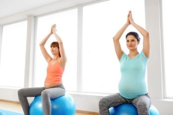 pregnancy, sport, fitness, people and healthy lifestyle concept - group of happy pregnant women sitting on exercise balls in gym. pregnant women sitting on exercise balls in gym. pregnant women sitting on exercise balls in gym