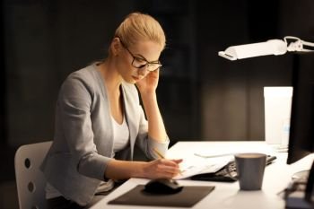 business, deadline and people concept - businesswoman with papers working at night office. businesswoman with papers working at night office. businesswoman with papers working at night office