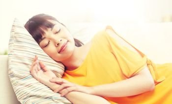 rest, relax and people concept - happy asian teenage girl or young woman sleeping on sofa at home. happy asian teenage girl sleeping on sofa at home. happy asian teenage girl sleeping on sofa at home