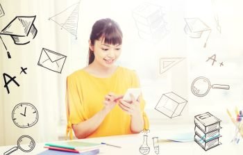 people, education, high school, technology and learning concept - happy asian young woman student with smartphone texting message at home with doodles. happy young woman student with smartphone at home. happy young woman student with smartphone at home