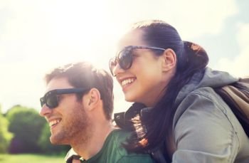 travel, hiking, backpacking, tourism and people concept - happy couple in sunglasses with backpacks having fun and hugging outdoors. happy couple with backpacks having fun outdoors. happy couple with backpacks having fun outdoors