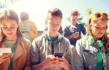 technology, internet addiction and people concept - group of teenage friends or high school students with smartphones outdoors. group of teenage friends with smartphones outdoors. group of teenage friends with smartphones outdoors