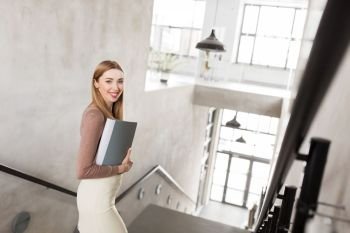 people, business and career concept - happy smiling woman with folder walking downstairs. happy woman with folder walking downstairs. happy woman with folder walking downstairs