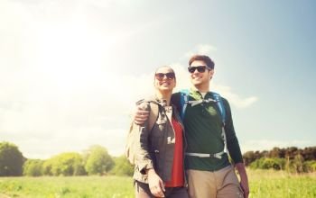 travel, hiking, backpacking, tourism and people concept - happy couple with backpacks hugging and walking outdoors. happy couple with backpacks hiking outdoors. happy couple with backpacks hiking outdoors