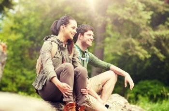 travel, hiking, backpacking, tourism and people concept - smiling couple with backpacks resting in nature. smiling couple with backpacks in nature. smiling couple with backpacks in nature