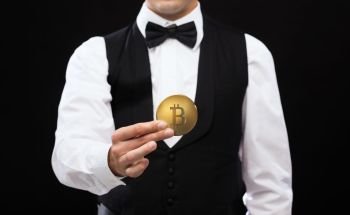 cryptocurrency, financial technology and business concept - close up of casino dealer holding bitcoin over black background. close up of casino dealer holding bitcoin. close up of casino dealer holding bitcoin