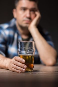 alcoholism, alcohol addiction and people concept - male alcoholic drinking beer from glass at night. alcoholic drinking beer from glass at night. alcoholic drinking beer from glass at night