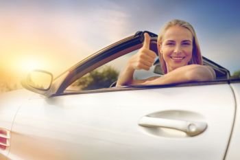 travel, road trip and people concept - happy young woman showing thumbs up in convertible car. happy young woman in convertible car thumbs up. happy young woman in convertible car thumbs up