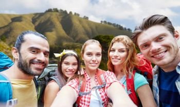 technology, travel, tourism, hike and people concept - group of smiling friends with backpacks taking selfie over big sur of california hills background. friends with backpack taking selfie over big sur. friends with backpack taking selfie over big sur