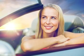 travel, road trip and people concept - happy young woman in convertible car over sunset sky background. happy young woman in convertible car. happy young woman in convertible car