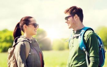 travel, hiking, backpacking, tourism and people concept - happy couple with backpacks talking outdoors. happy couple with backpacks hiking outdoors. happy couple with backpacks hiking outdoors