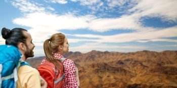 travel, tourism, hike and adventure concept - couple of travelers with backpacks over grand canyon national park hills background. couple with backpacks over grand canyon. couple with backpacks over grand canyon
