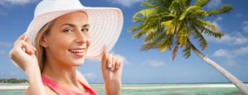 travel, summer holidays and tourism concept - portrait of beautiful smiling woman in sun hat over exotic tropical beach with palm trees background. portrait of smiling woman in sun hat over beach. portrait of smiling woman in sun hat over beach