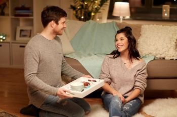 leisure, hygge and people concept - happy couple with food on tray at home. happy couple with food on tray at home. happy couple with food on tray at home