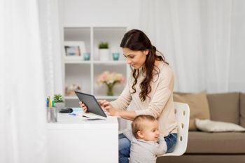 multi-tasking, education, motherhood and technology concept - happy mother student with baby and tablet pc computer learning at home. mother student with baby and tablet pc at home. mother student with baby and tablet pc at home