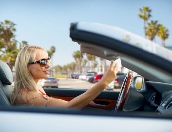 travel, road trip and people concept - happy young woman in convertible car taking selfie by smartphone over venice beach background in california. woman in convertible car taking selfie over beach. woman in convertible car taking selfie over beach