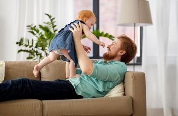 family, fatherhood and people concept - happy red haired father with little baby girl at home. happy father with little baby girl at home. happy father with little baby girl at home