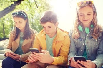 technology, internet and people concept - group of happy teenage friends with smartphone and headphones outdoors. teenage friends with smartphone and headphones. teenage friends with smartphone and headphones