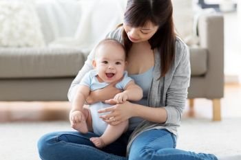 family and motherhood concept - happy smiling young asian mother with little baby at home. happy young mother with little baby at home. happy young mother with little baby at home