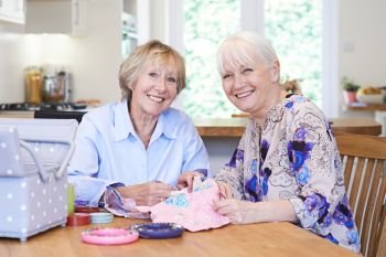 Portrait Of Two Senior Women Sewing Quilt Together