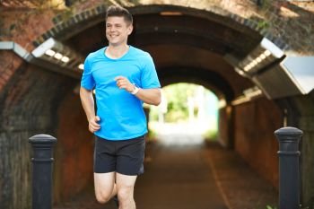 Man Wearing Fitness Tracker Running In Urban Environment