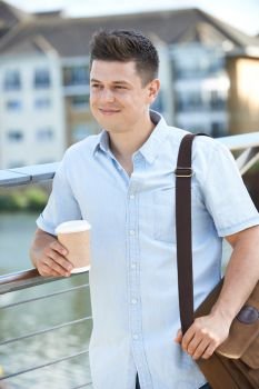 Man With Takeaway Coffee Walking To Work In Urban Setting