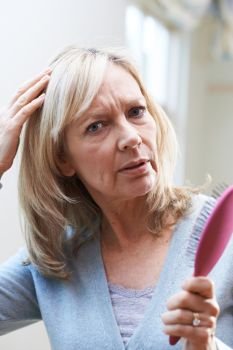 Mature Woman With Brush Corncerned About Hair Loss