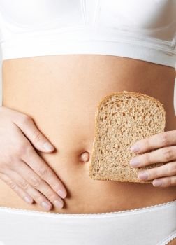 Close Up Of Woman Wearing Underwear Holding Slice Of Brown Bread And Touching Stomach