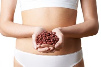Close Up Of Woman In Underwear Holding Handful Of Red Kidney Beans