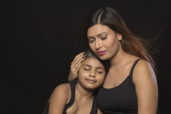 Portrait of mother embracing daughter eyes closed