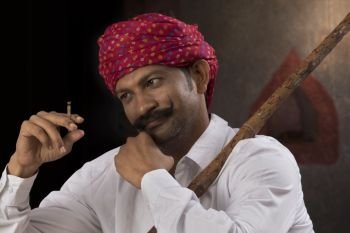 Farmer wearing turban and smoking cigar 
