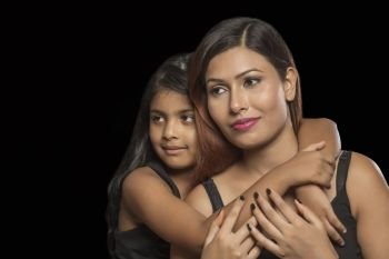 Portrait of daughter embracing her mother from behind